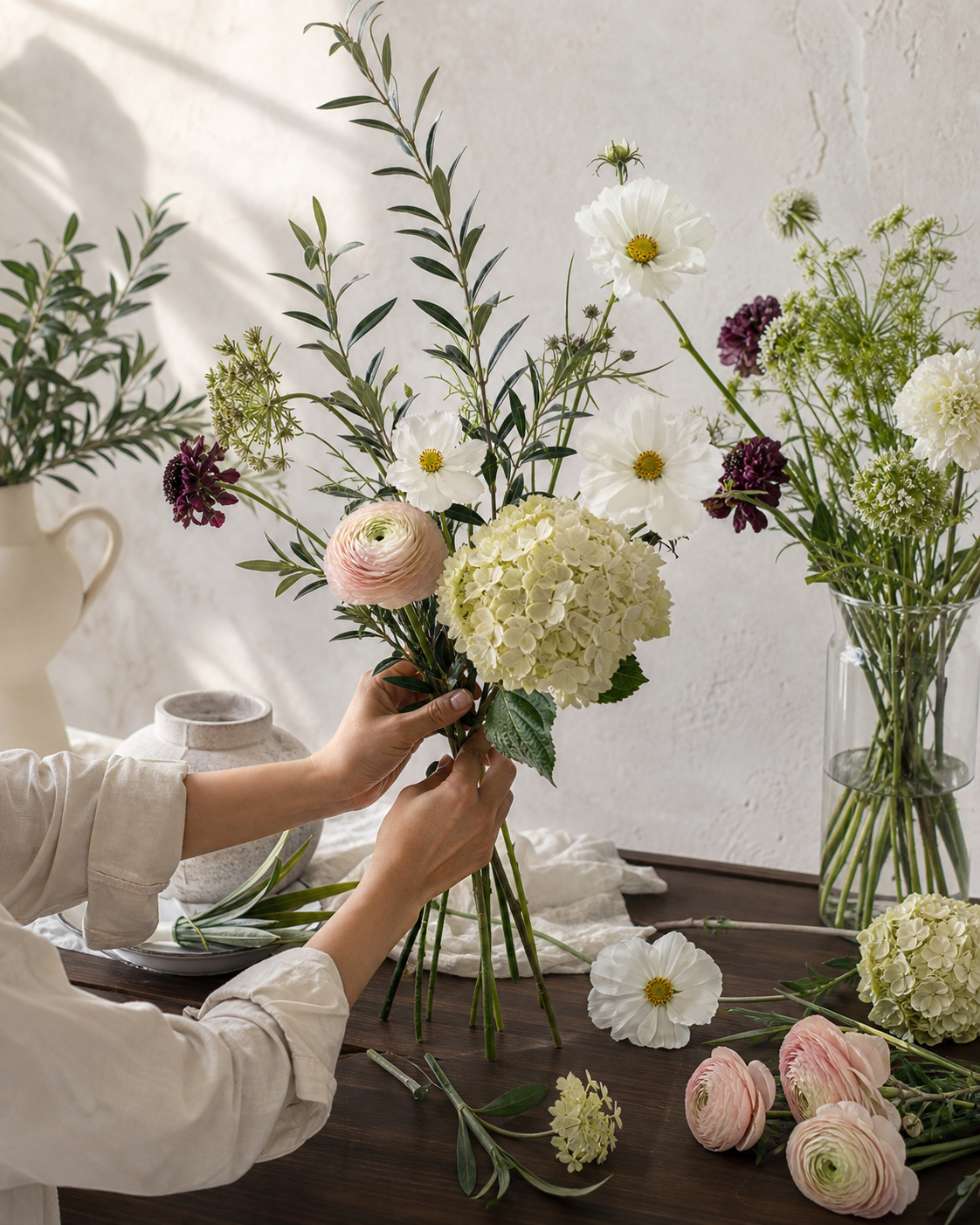 Hands composing a permanent botanical arrangement